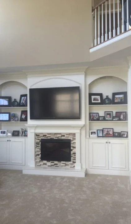 Full wall fireplace surround with custom millwork and built-in mantel